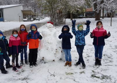 Kinder bauen Schneemann