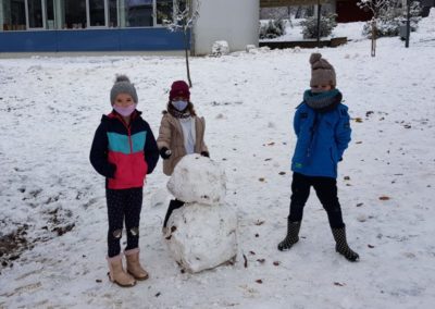 Kinder bauen Schneemann