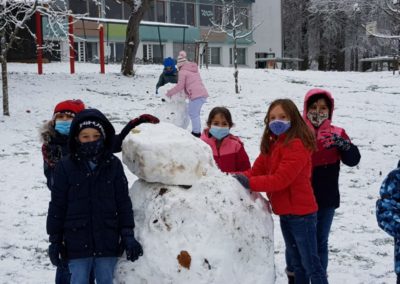 Kinder bauen Schneemann