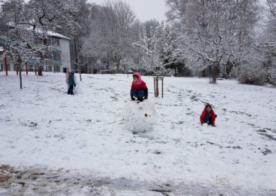 Kinder bauen Schneemann
