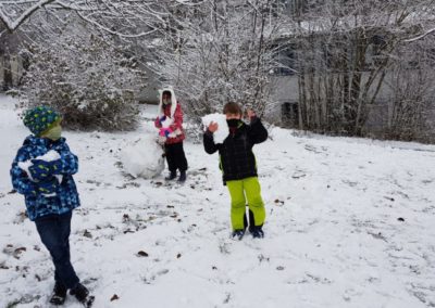 Kinder bauen Schneemann