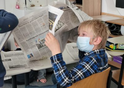 Kinder beim Lesen der Tageszeitung